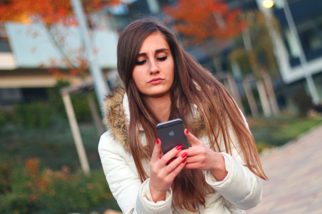 Woman Researching Substance Abuse Treatment Options for Parolees After Prison On Her Smartphone