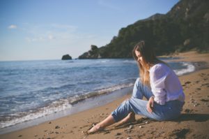 Woman sitting by the sea