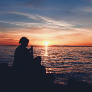 Woman using an app with sunset