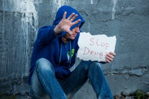 Man holding up a stop drugs sign