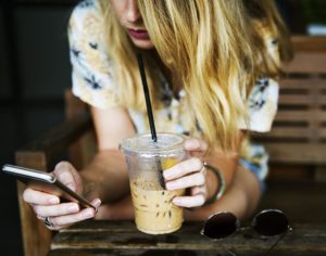 Woman with smartphone and coffee