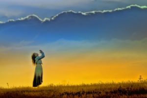 Woman praying in the sunset