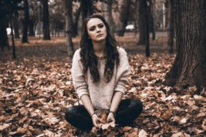 Upset Woman Sitting Outside In Leaves