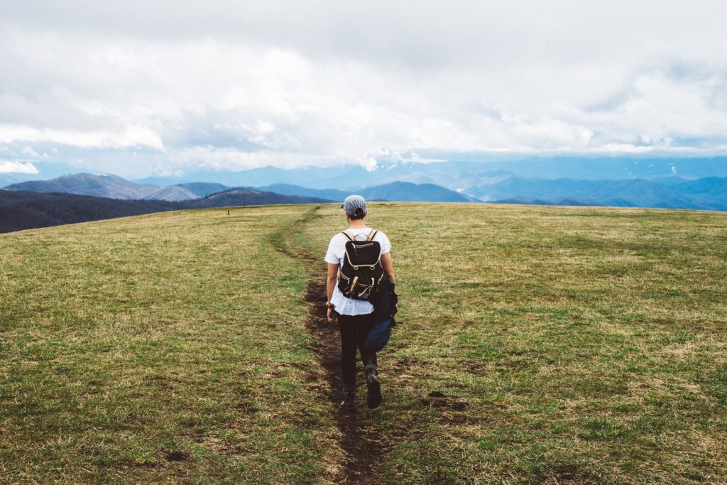 Man climbing mountain working on thinking about Addiction Recovery Stories