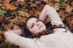 Millennial laying in the leaves thinking about treatment for depression with Psilocybin