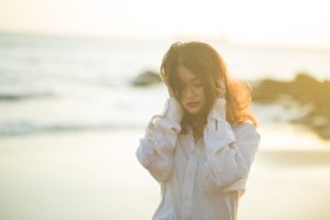 Woman walking on the beach, struggling with drug abuse