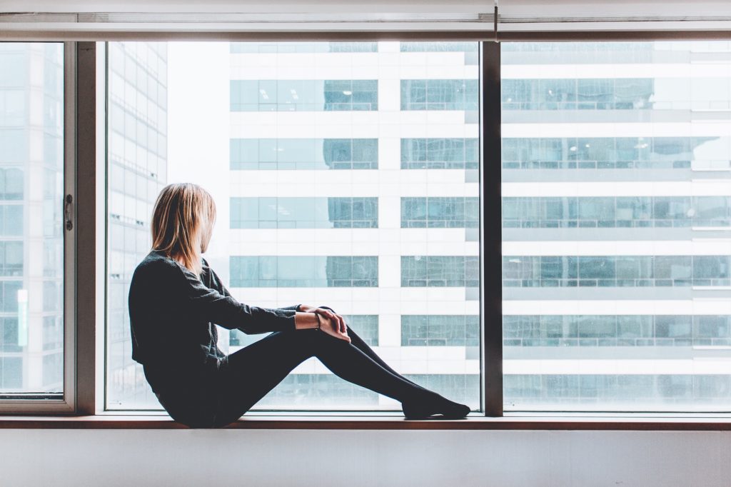 Woman sitting in window sill