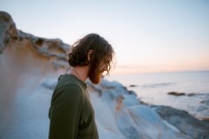 Man standing outside, struggling with pain management