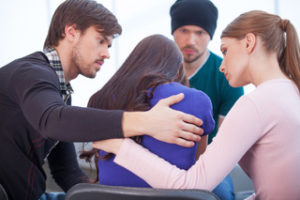 Group of people comforting someone with sexual addiction