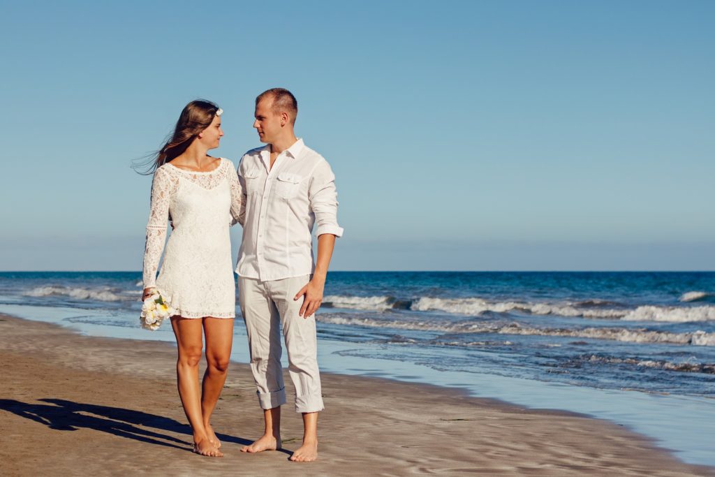 Couple walking on the beach after being married