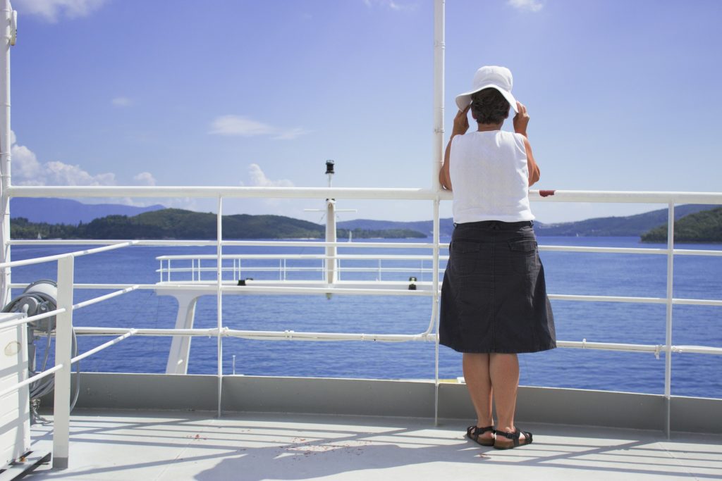 Older Woman standing on a deck of a ship contemplating Alcohol Use Disorders in Older Women