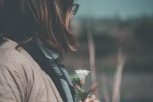 Woman holding flower and thinking about opioid overdose