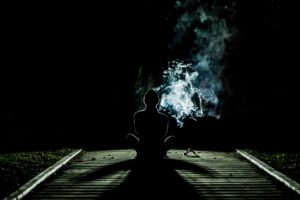 man smoking on a bridge