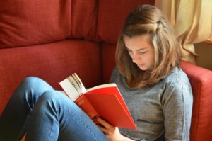 Teen girl reading a book during the Coronavirus crisis