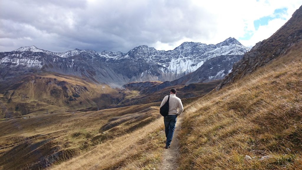 Man walking a trail in the mountains