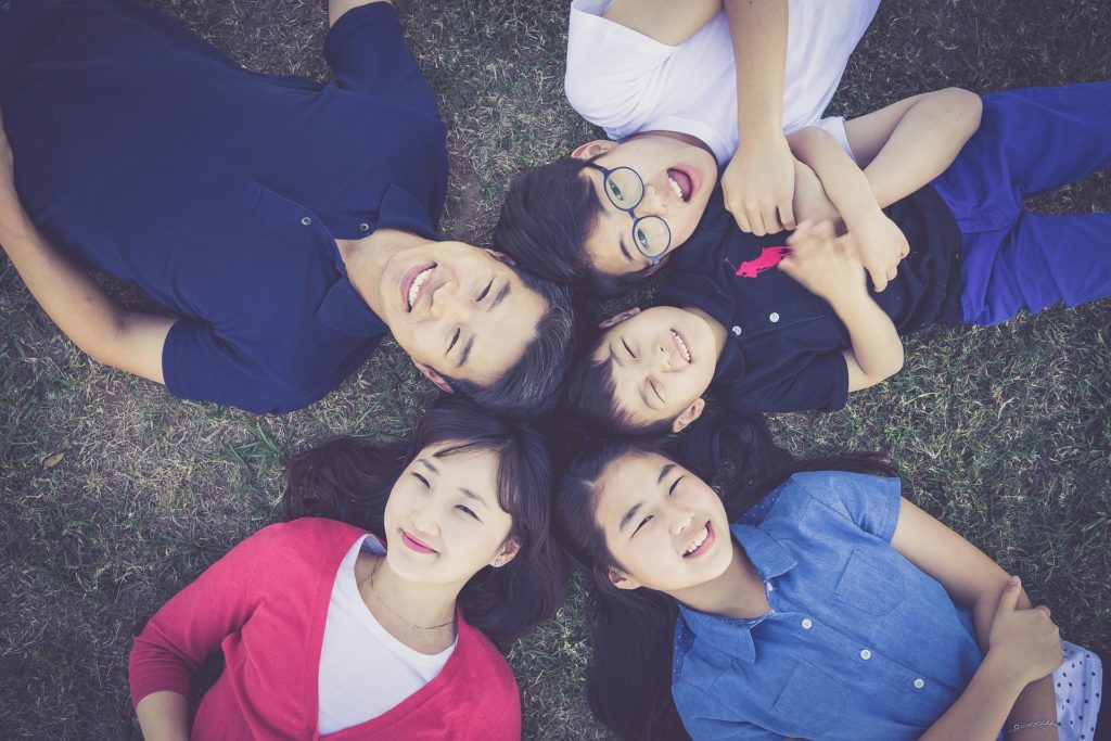 Aisian Family Laying on Ground in Circle