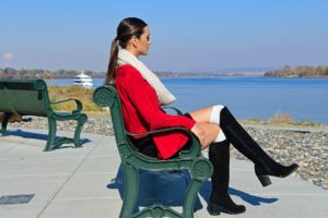 Hispanic Woman Sitting on Bench Near Sea